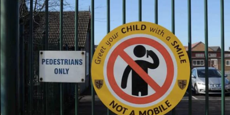 Primary school erects signs banning parents from being on their phones at pickup
