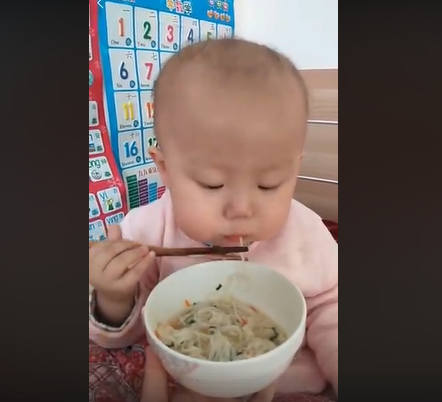 This baby casually eating noodles puts our chopstick skills to shame